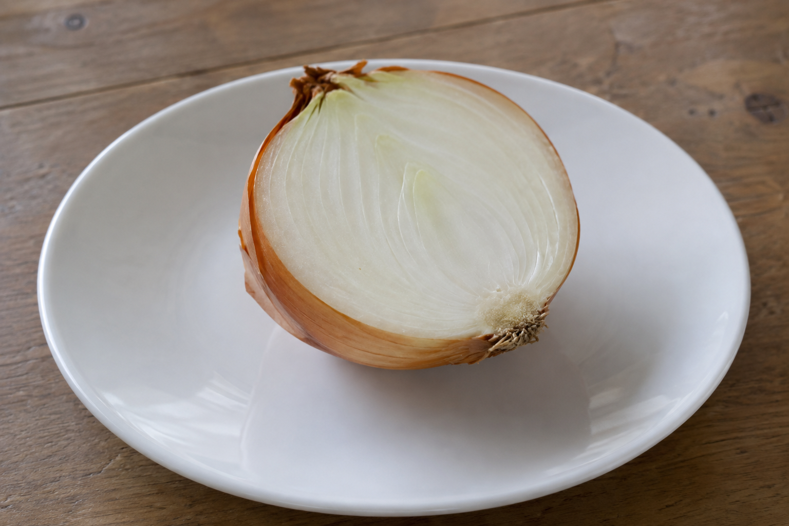 白い皿に置いた半分の生の玉ねぎを描いたAI生成の料理素材参考画像